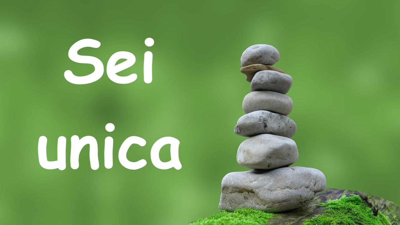 foto di pietre in equilibrio zen con sfondo verde e scritta sei unica  